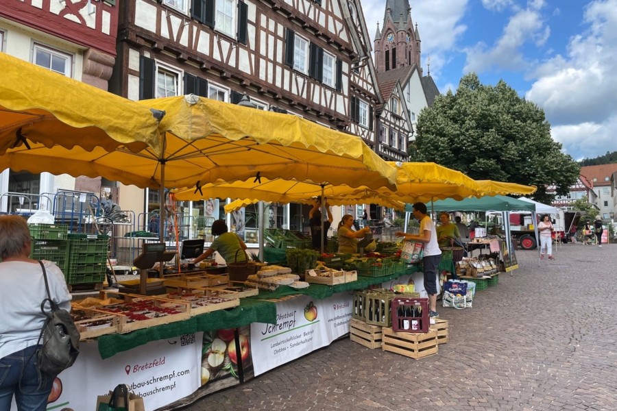 Marktstände von Obstbauern auf einem Wochenmarkt in einer Altstadt