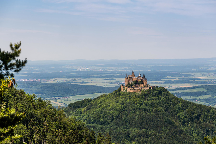 Blick auf die Burg Hohenzollern und die umliegenden Wälder und Wiesen der Schwäbischen Alb.