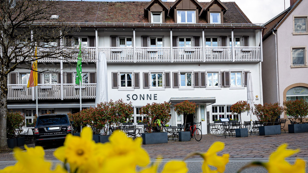 Frontansicht des Hotels Sonne in Kirchzarten mit gelben Narzissen im Vordergrund