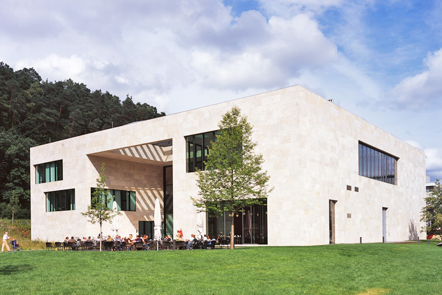 Außenansicht des Ritter Sport Museums in Waldenbuch. Das Gebäude ist modern mit einer weißen Fassade und hat eine rechteckige Form. Davor ist eine große Wiese.