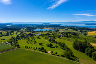 Panoramablick auf einen Golfplatz bei strahlend-blauem Himmel