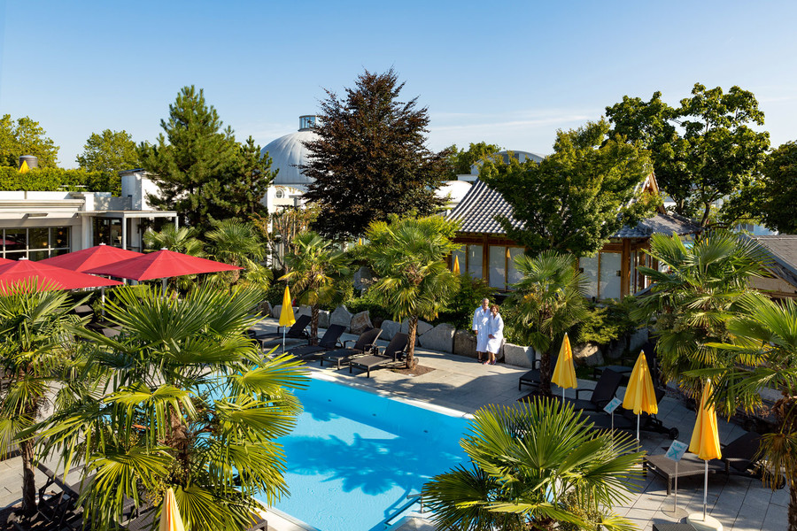 Außenbereich des Vita Classica Spa-Resort mit einem Pool und vielen Palmen.