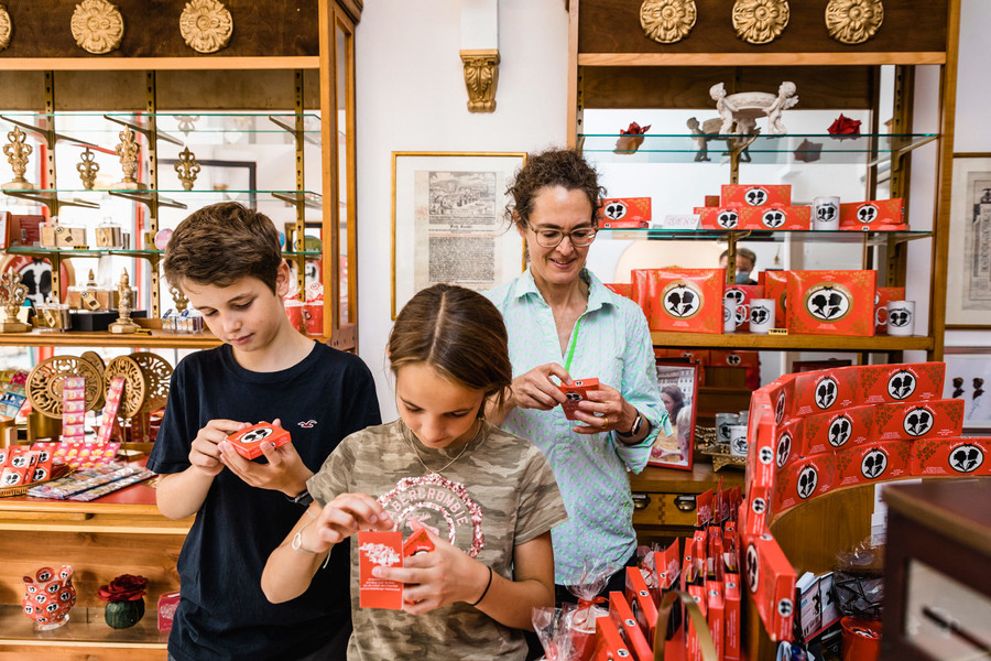 Eine Mutter steht mit ihrem Sohn und ihrer Tochter in einem Heidelberger Laden mit Süßigkeiten.