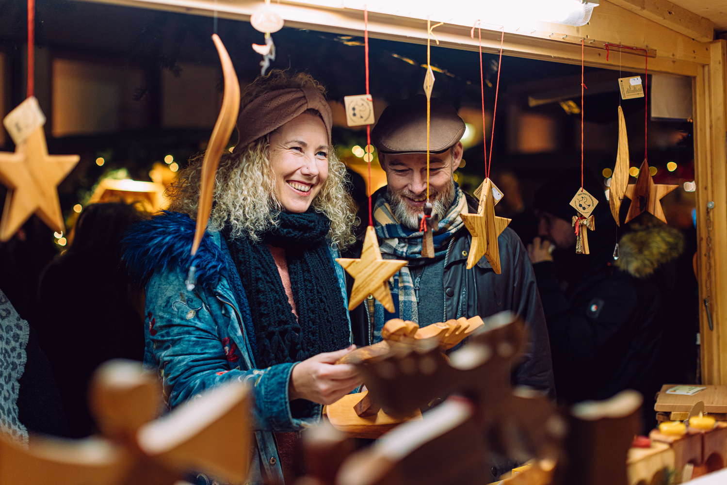 Eine Frau und ein Mann an einem Weihnachtsmarktstand