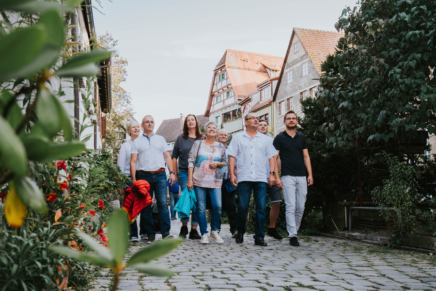 Eine Gruppe verschiedener Personen macht eine Stadtführung durch das Fischerviertel in Ulm.